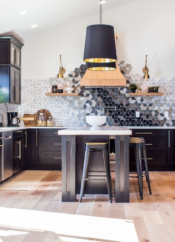 a black kitchen with a beautiful geometric ombre tile backsplash that is a whole masterpiece in here