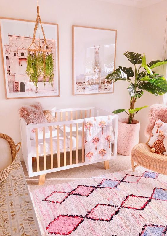 25 a tropical nursery with pink walls, printed rugs and towels, a potted plant and a matching mobile is cool