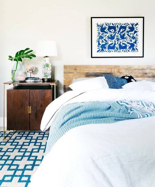 a modern coastal bedroom with blue textiles and a bold blue artwork looks very stylish and bold