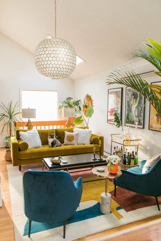 A vibrant mid century modern living room in navy, white and mustard, with a colorful gallery wall and potted plants