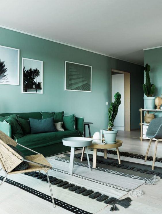 28 a serene monochromatic living room with light green walls, dark green furniture, wooden tables and potted plants