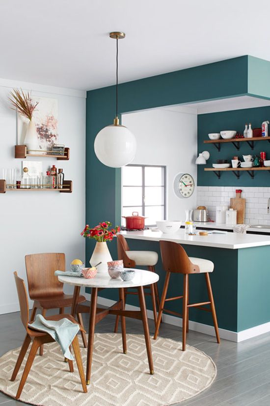29 a modern teal kitchen separated from the rest of the space with a kitchen island, with a white tile backsplash and countertops