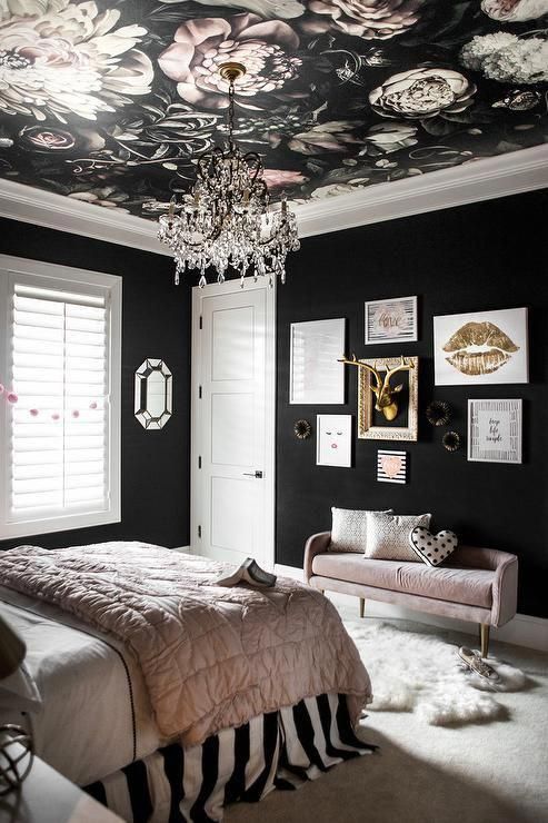 a glam black and blush bedroom with black walls, a moody floral ceiling, a gallery wall with gold and pink bedding