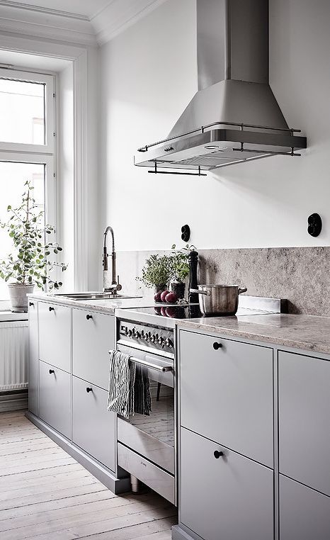 34 a Scandinavian grey kitchen with a greige stone backsplash and countertops, black fixtures and knobs