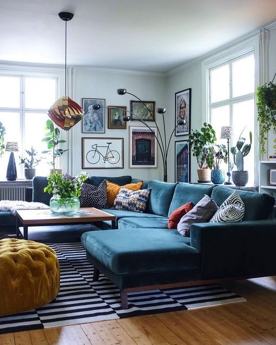 34 a Scandinavian inspired living room with light blue walls, a navy sectional, a bold gallery wall and touches of copper and black