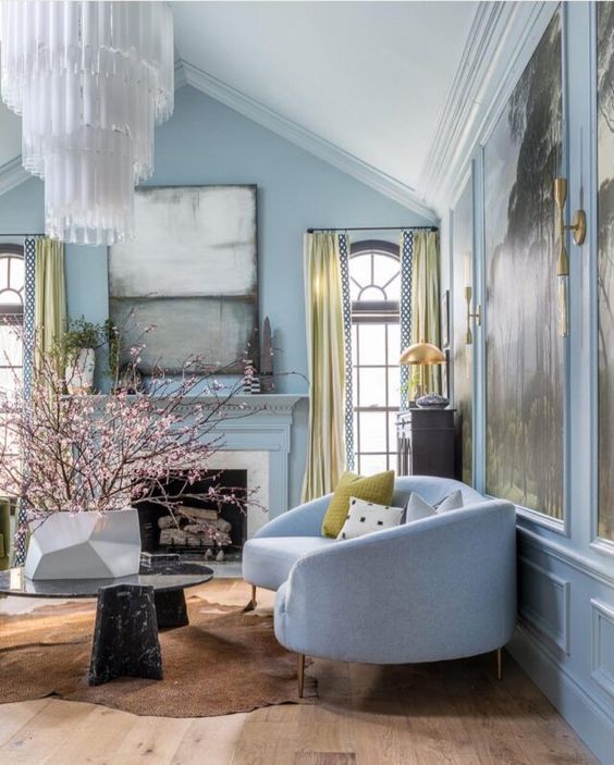 35 a refined living room with light blue walls, exquisite furniture, a statement chandelier and statement artworks
