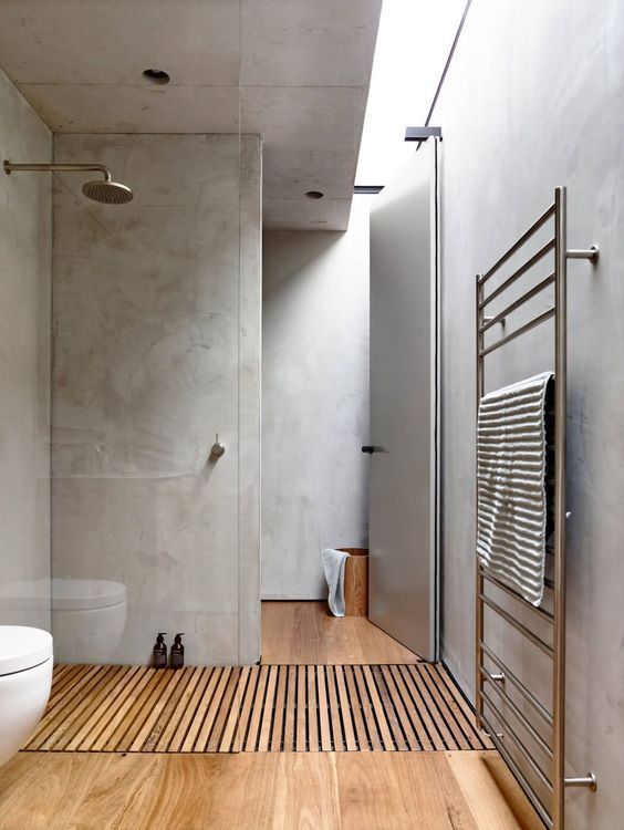 a minimalist bathroom with concrete walls and a skylight, a wooden floor plus neutral appliances
