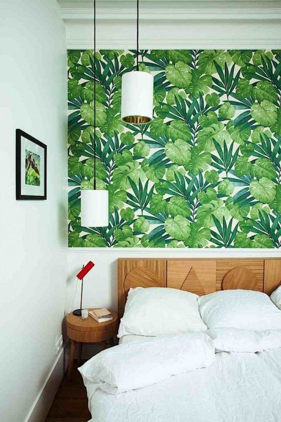 38 a bold modern bedroom with tropical leaf wallpaper, a catchy wooden bed and round nightstands plus pendant lamps