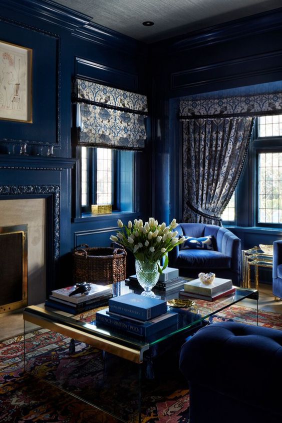 41 a monochromatic refined navy living room with a fireplace, chic navy furniture, printed textiles and baskets