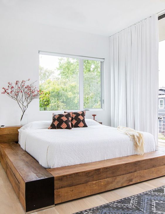 an airy bedroom with a bed made of wooden slab is a welcoming space with a strong rustic feel