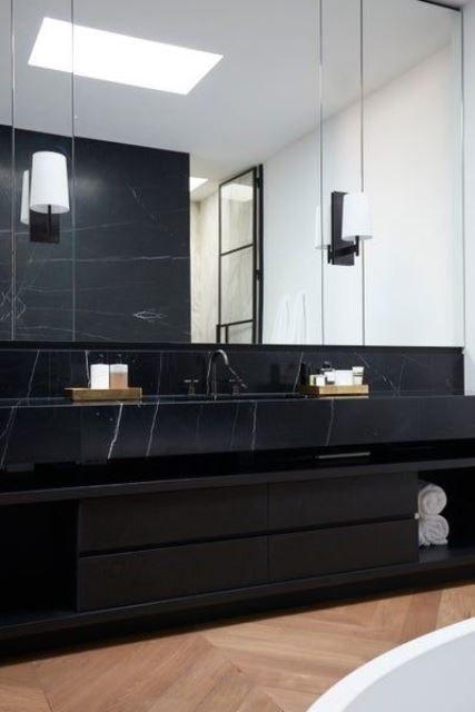 48 a refined contemporary bathroom with a black marble vanity, large mirrors and a skylight plus a bathtub