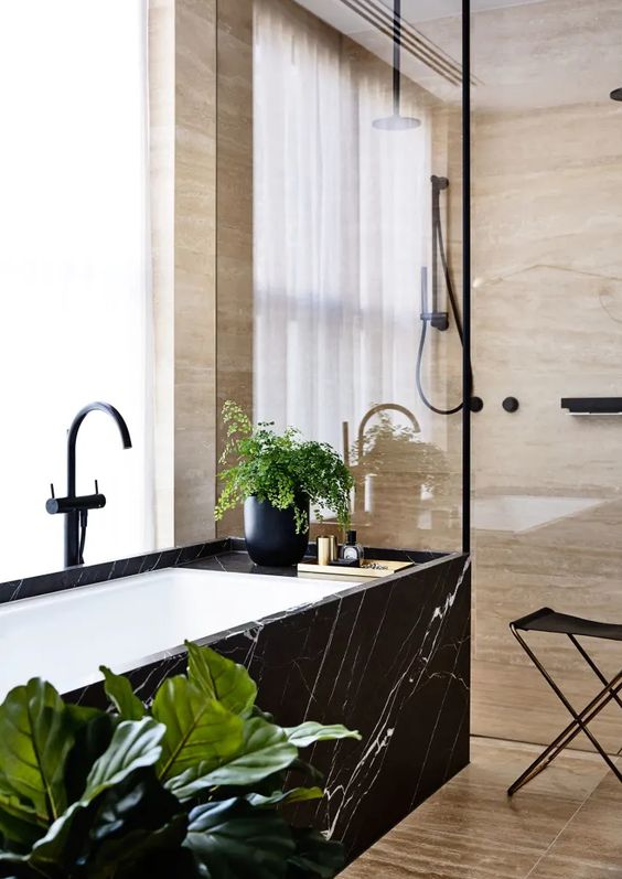 49 a beautiful bathroom with wood print tiles and a bathtub clad with black marble plus potted greenery