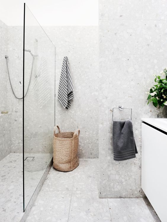 58 a beautiful neutral bathroom done with grey terrazzo, a basket, a white vanity and white appliances