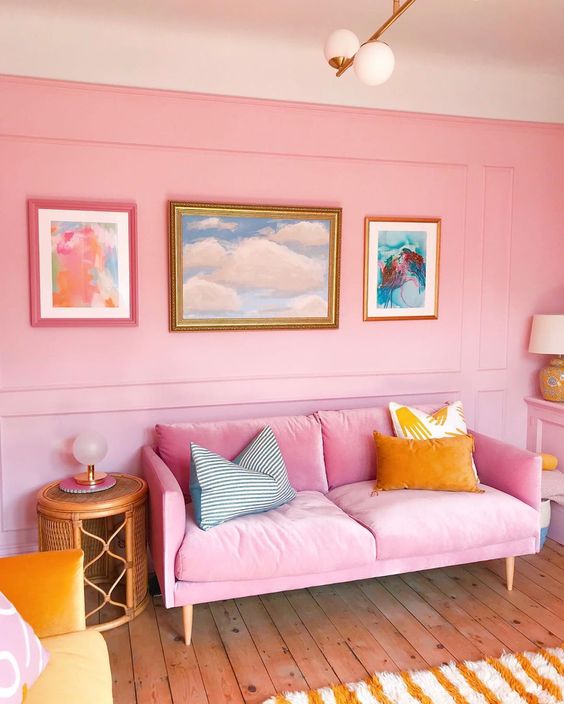 58 a colorful bright pink living room with a bright sofa, colorful pillows, bold artworks and lamps