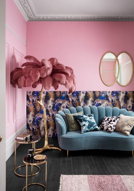 59 a colorful and whimsical living room with bright pink walls, a blue sofa, a peacock feather wall and a feather lamp
