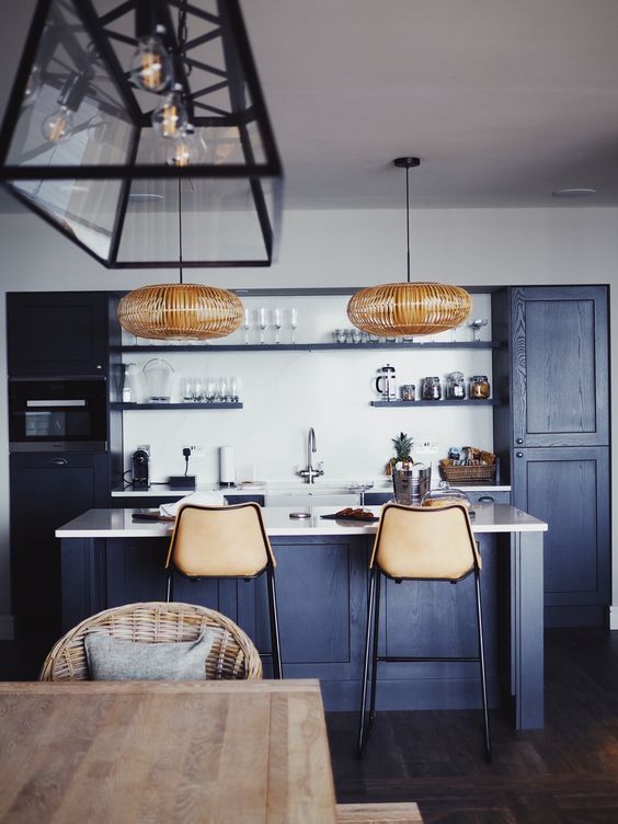 59 a cool contemporary navy kitchen with white countertops and a backsplash, rattan lamps and leather stools