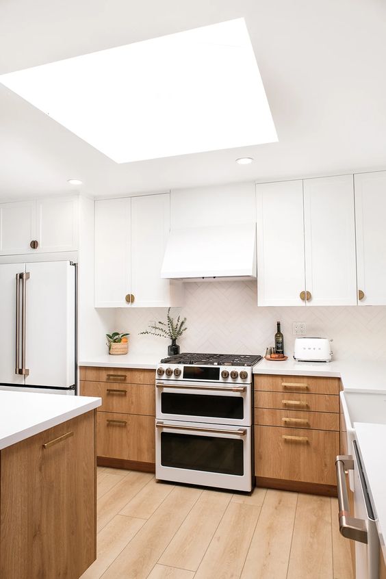 71 a two tone kitchen with white and ligth stained cabinets, a white chevron tile backsplash and countertops
