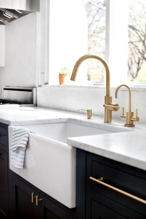 a black and white kitchen accented with gold fixtures and appliances is a stylish and shiny idea