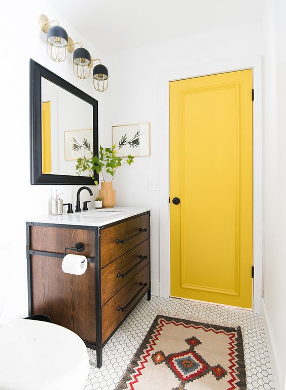 84 a small and bright bathroom with a yellow door for a touch of color and black fixtures to contrast it