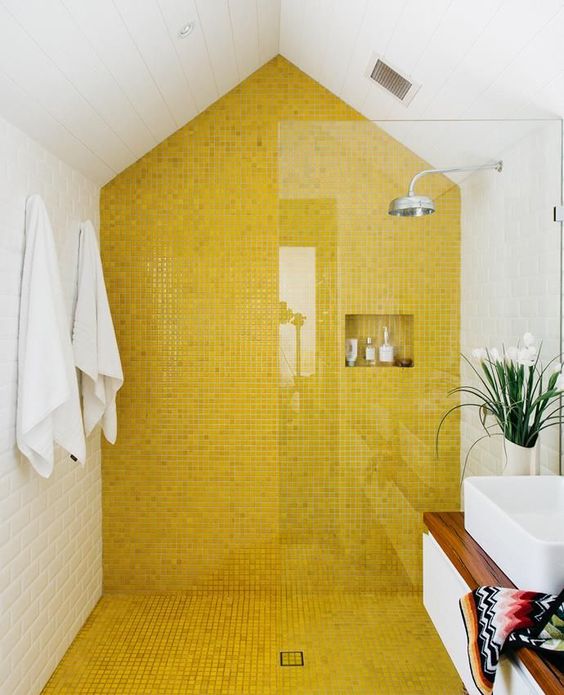 a contemporary bathroom with a bold yellow tile wall and floor in the shower to make this space bolder and catchier