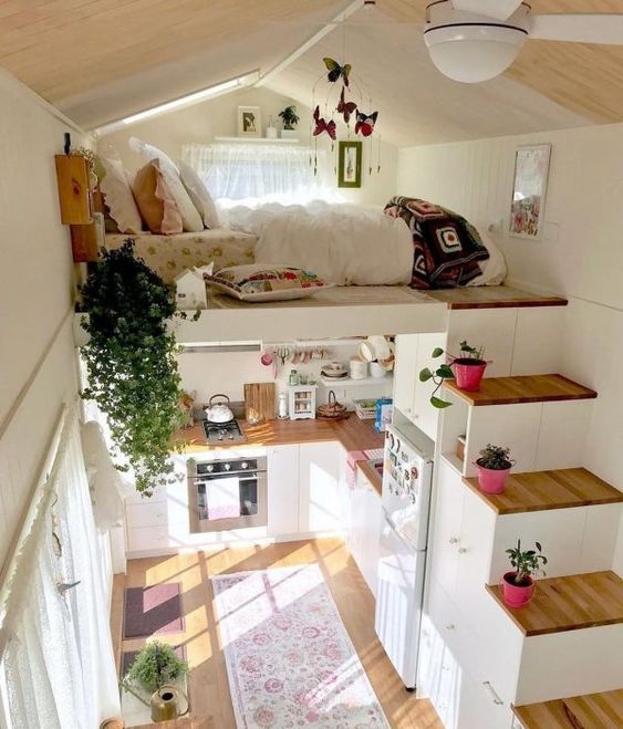 a small house with a loft bedroom and a storage stairs plus a kitchen down contains everything you may need for living