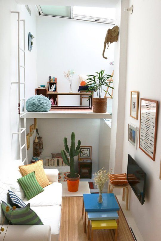 a tiny colorful apartment with a living room, a bedroom down and a loft workspace with a skylight over it is fun