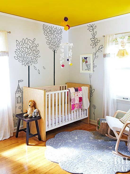 a whimsy nursery with a yellow ceiling, simple furniture, painted walls, a blue rug, bold textiles and toys
