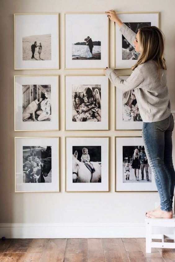 03 a stylish and elegant gallery wall with black and white family pics in gilded frames is a pretty solution for your home