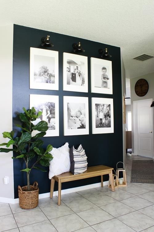 a stylish grid gallery wall with matching white frames and lights to accent it is a cool idea with a modern feel