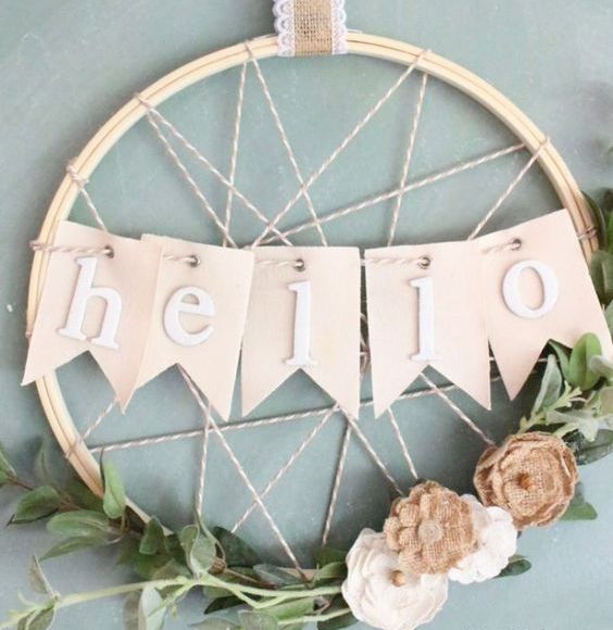 05 a creative rustic spring wreath with yarn, a HELLO banner, some greenery and fabric blooms is all cool