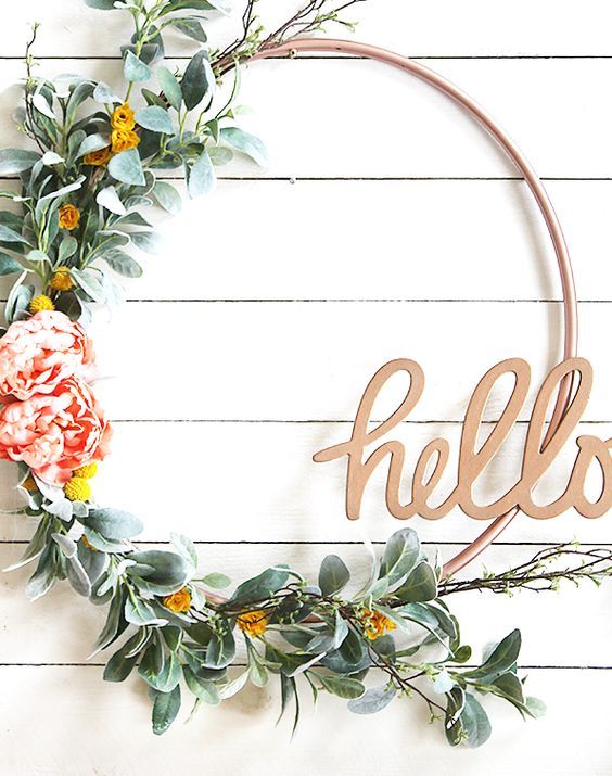 a cute spring wreath of a hoop, faux greenery, yellow and pink blooms and a HELLO calligraphy piece