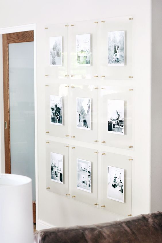 a floating gallery wall with clear acrylic frames and gold pins is a stylish idea that looks ultra-modern and outstanding