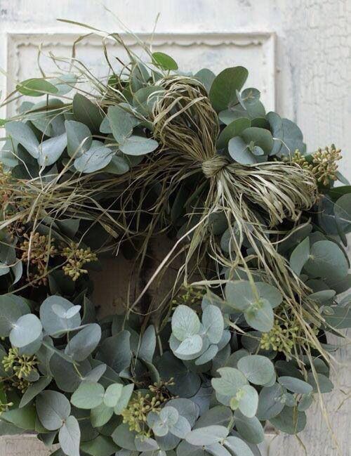 a greenery and grass wreath with seeds is a very fresh and natural idea for a modern space