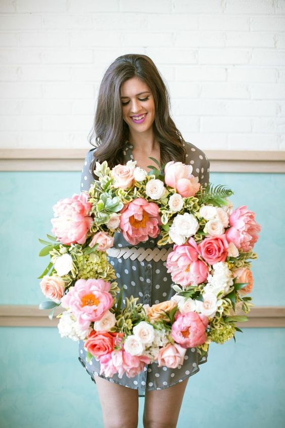 a lush artificial pink flower wreath with some white blooms and greenery is a great idea for spring and it will last long
