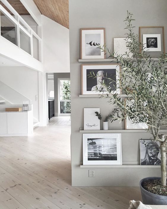 21 a chic contemporary gallery wall with grey ledges on a matching wall, black and white photos in mismatching frames