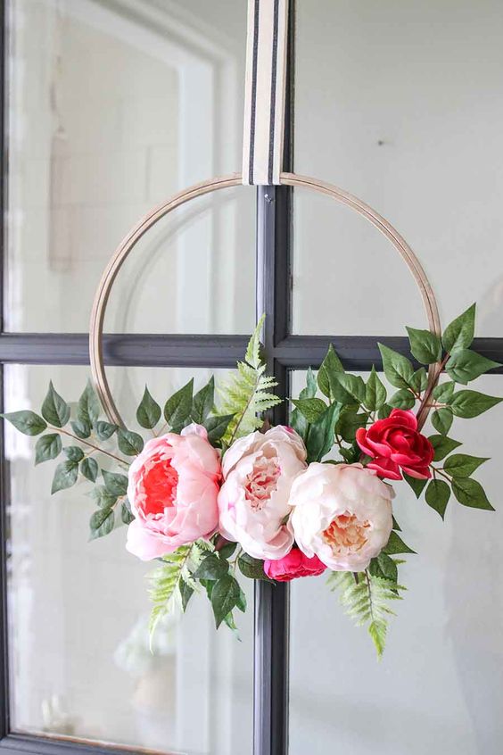 a modern spring floral wreath of a hoop, oversized blush, pink and red blooms and foliage is a gorgeous idea for spring or summer
