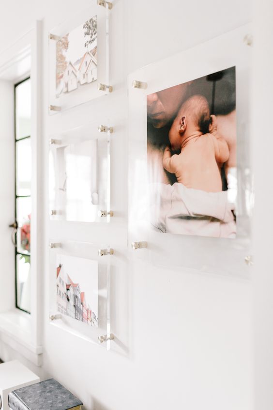 a floating gallery wall with clear acrylic frames and a free form is modern cause of its frames