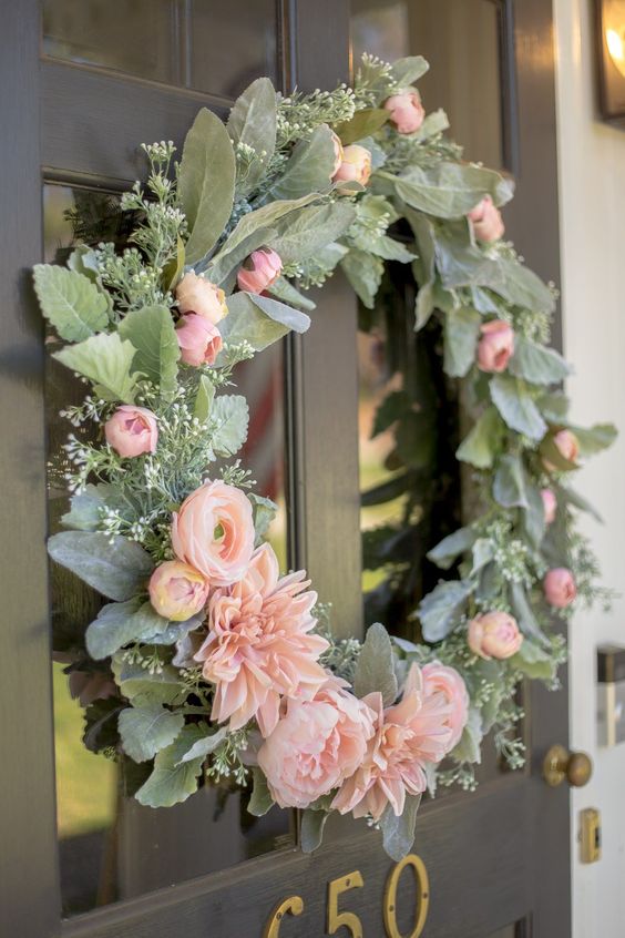 a pretty and cool spring wreath with pale greenery, pink blooms and foliage is a very beautiful idea for your front door