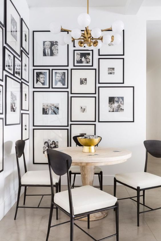 a modern and elegant free form gallery wall covering a whole corner and with matching black frames and white mats is wow