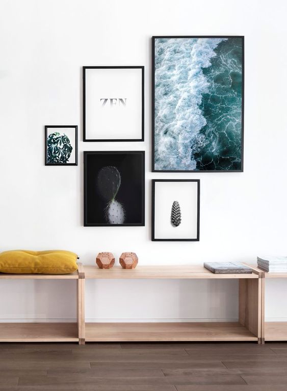 A modern free form gallery wall with mismatching frames and ultra modern artworks and prints looks fresh and bold
