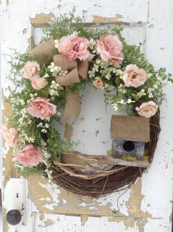 32 a rustic spring wreath of vine, greenery, white and pink blooms, a mini bird house and some moss