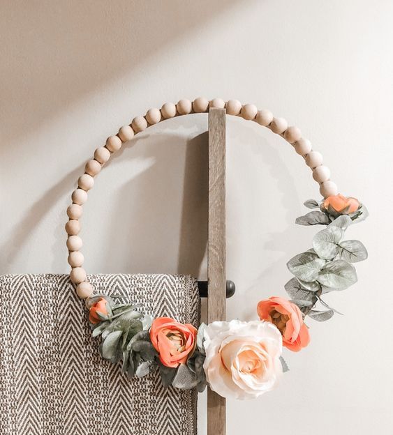 38 a spring wreath of wooden beads, with faux foliage and orange and white blooms is a modern idea for a front door
