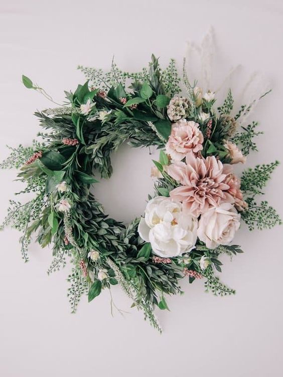 a stylish spring wreath of lots of textural greenery, white and pink blooms is a very fresh idea
