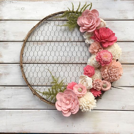a simple rustic spring wreath of chicken wire, vine, pink faux blooms and fabric ones plus greenery