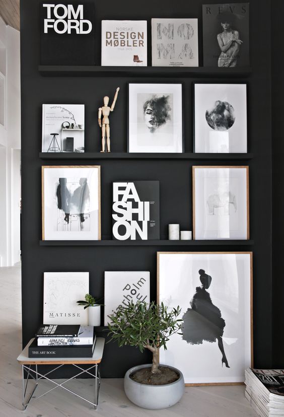 a black wall plus black ledges that merge with the wall and make the bold black and white artworks look floating in the air
