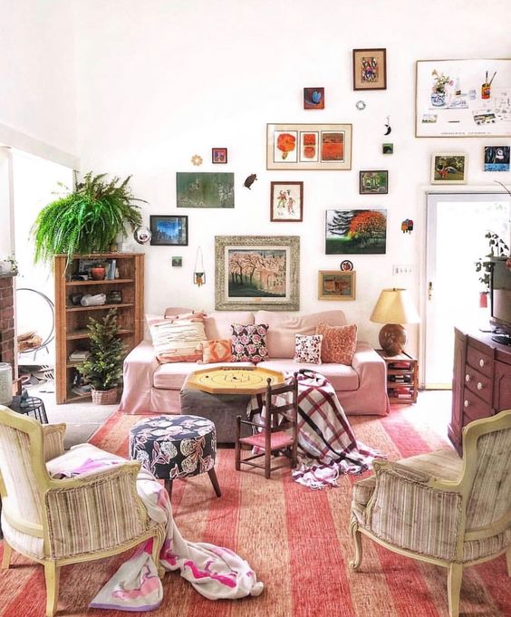 a bright eclectic gallery wall with mismatching frames climbing up the wall and going over the doorway is a very creative idea