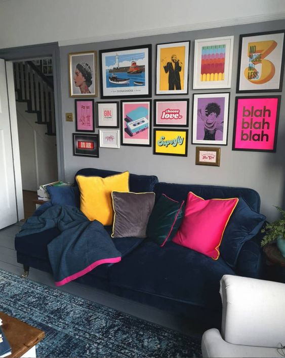 a bright pop art gallery wall with posters and prints in various colors united with the same style frames for a bold touch in a moody living room