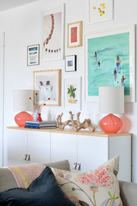 A cheerful vacation inspired gallery wall with mismatching frames and bright prints and artworks is bold and fun