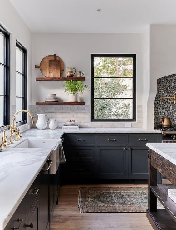 a chic dark grey farmhouse kitchen with white quartz countertops and a white marble tile backsplash, stained floating shelves and mixed metals