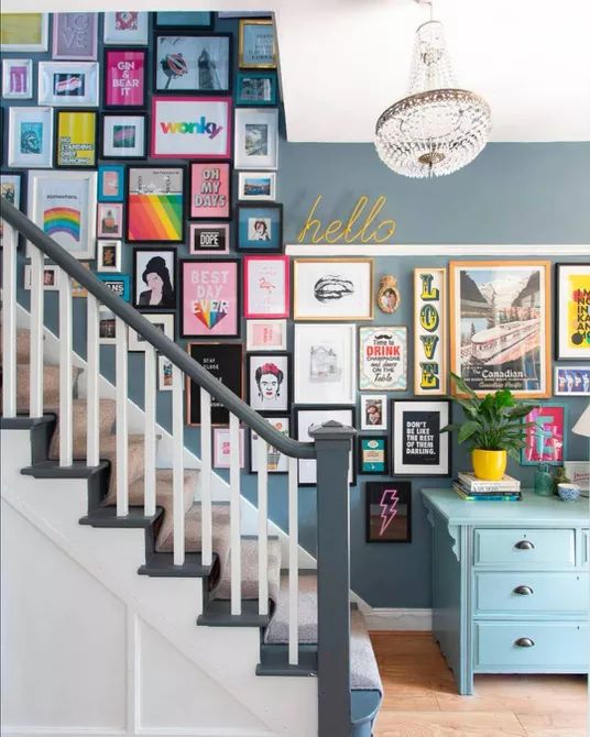 a colorful gallery wall over the stairs with mismatching frames and bold prints and posters will add color to the space